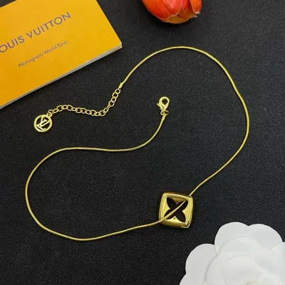 Gold-coloured pendant and its box on a dark tabletop